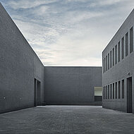 Schwarzer Monumentalbau vor roter Backsteinkulisse