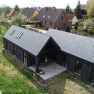 Rathscheck: Schieferdach eines Ferienhauses mit Systemdeckung von Rathscheck Schiefer effizient umgesetzt