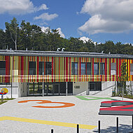 Braun-Steine: Farbige Schule mit lebendigem Pflasterbelag