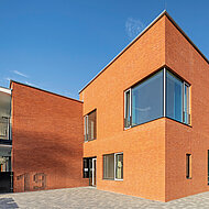 Hagemeister: Kindertagesstätte mit monochrom roter Gebäudehülle